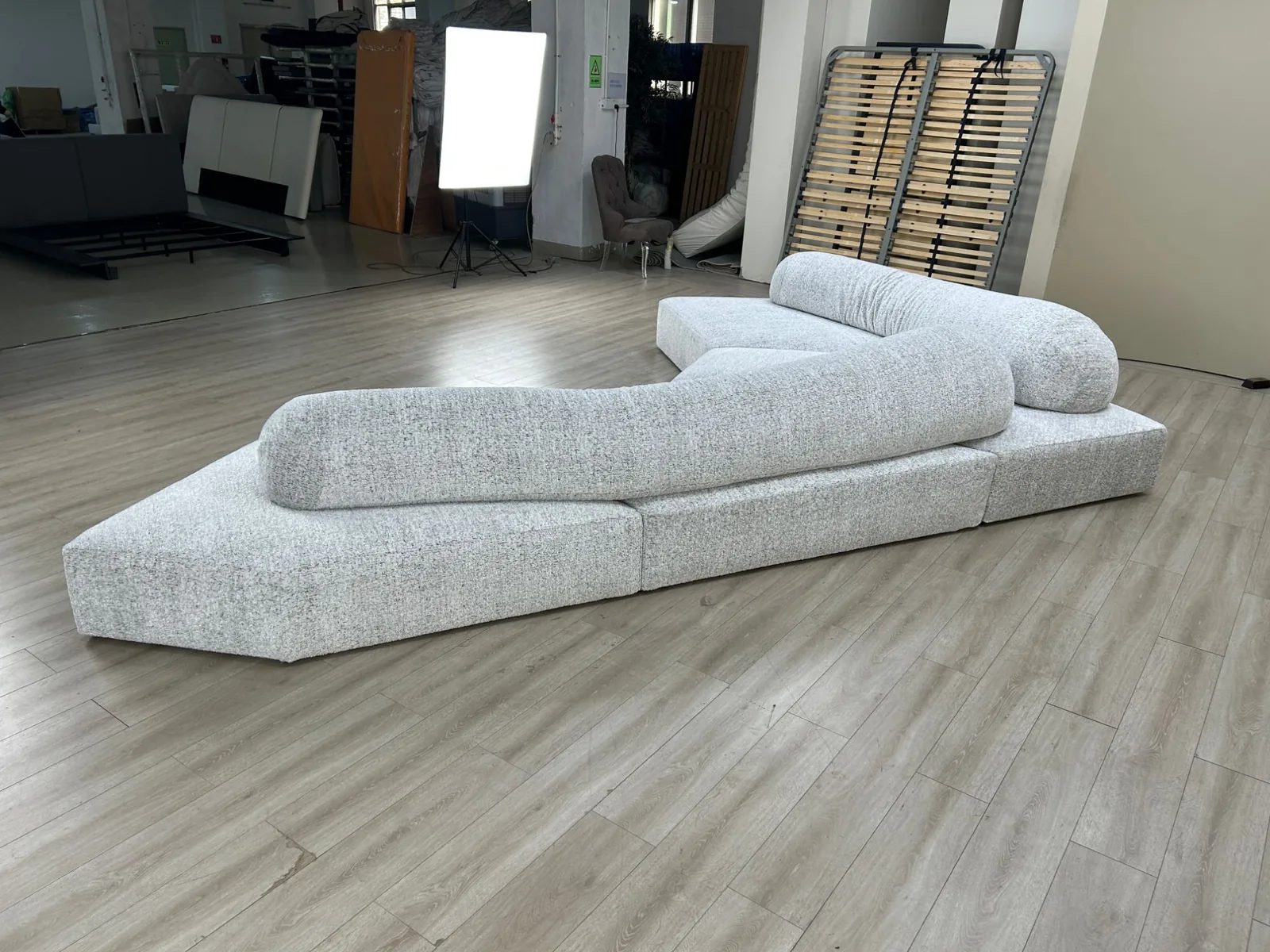Custom modular sofa in grey melange fabric with bolster backs arranged as a long low island