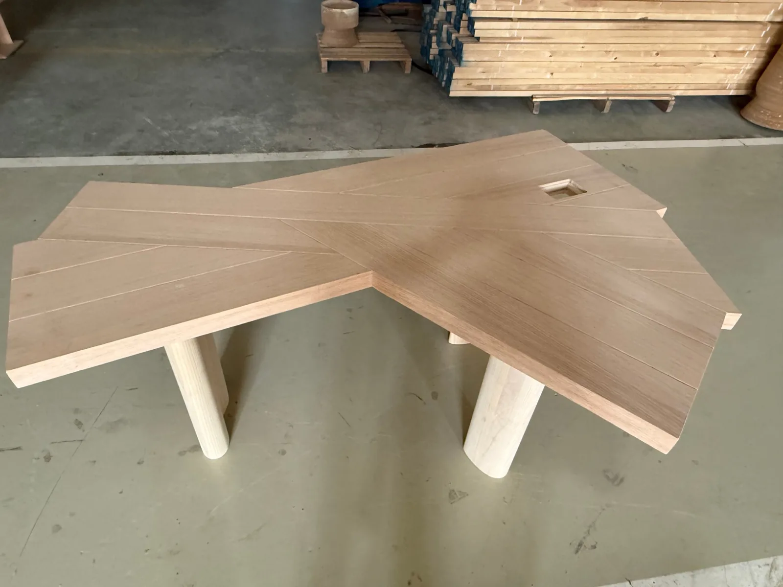 Top view of a custom angled oak desk with chevron veneer and a square cable cut-out