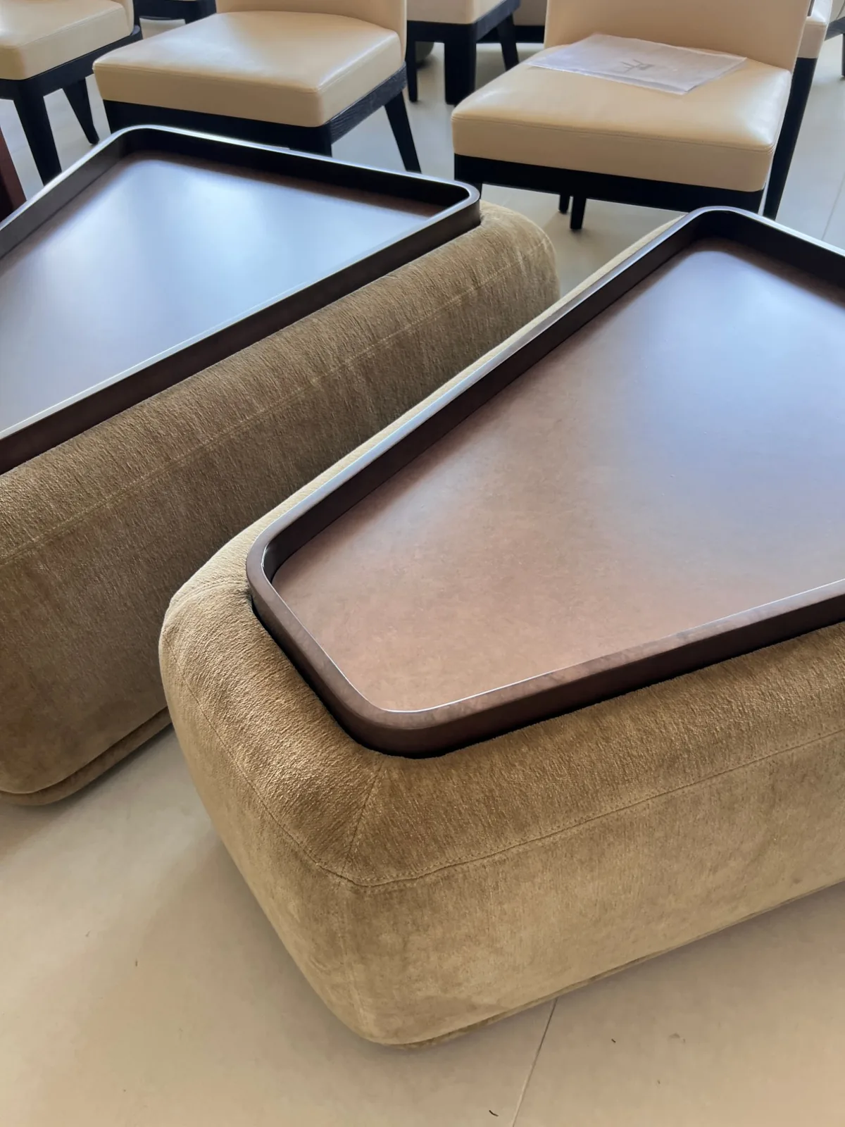 Two custom mohair ottomans with drop-in walnut trays, finished and set out for final inspection