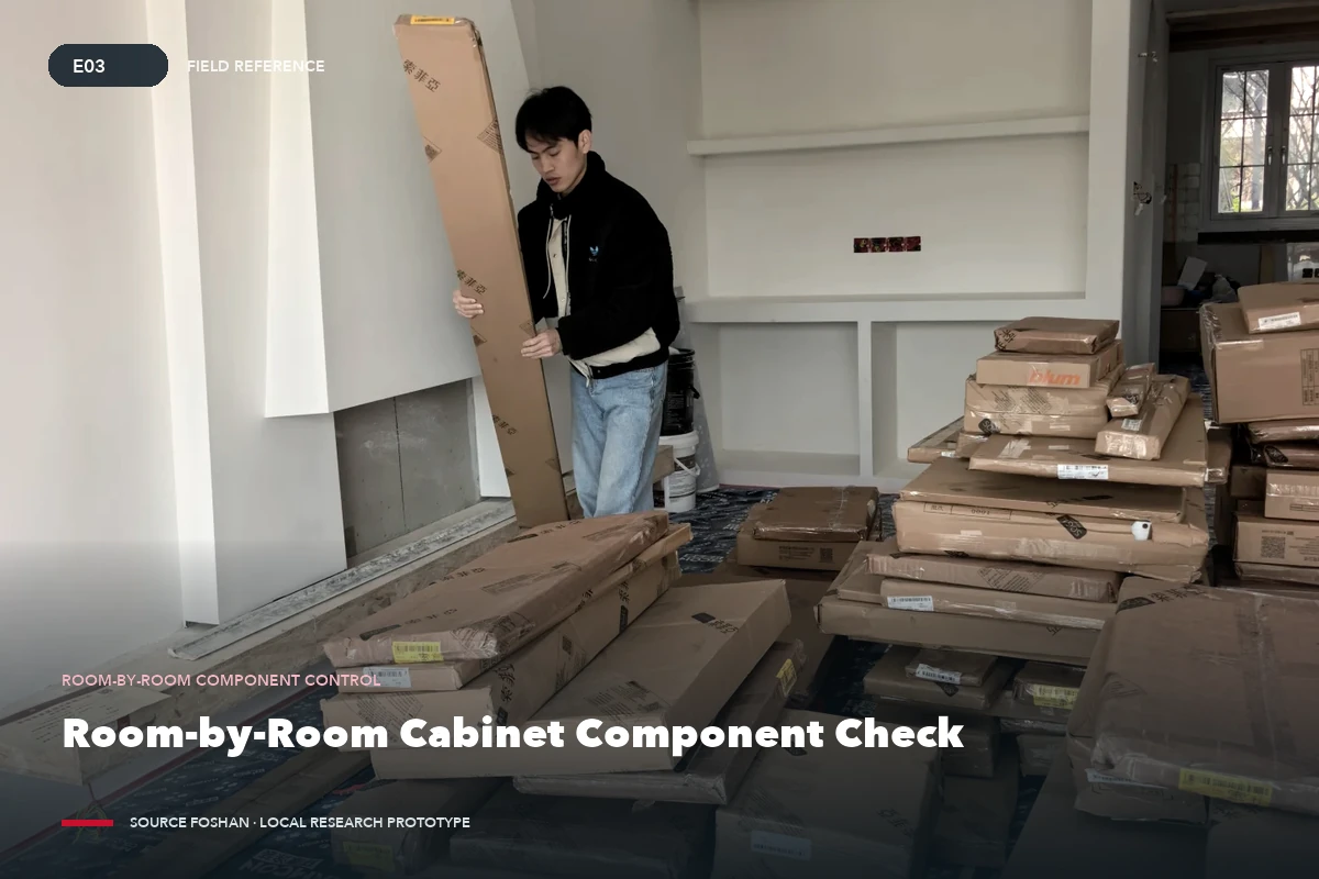 A person lifting a packaged cabinet component in a room before installation.
