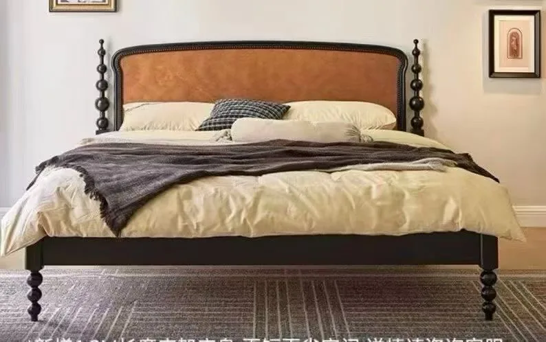 Black spindle bed with a tan leather headboard styled in a bedroom