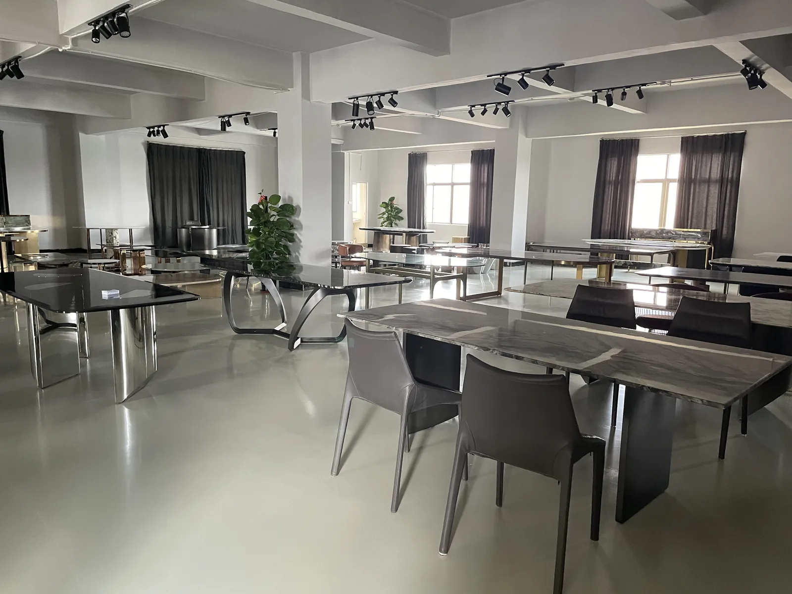Marble and sintered-stone dining tables with chairs on a Foshan showroom floor