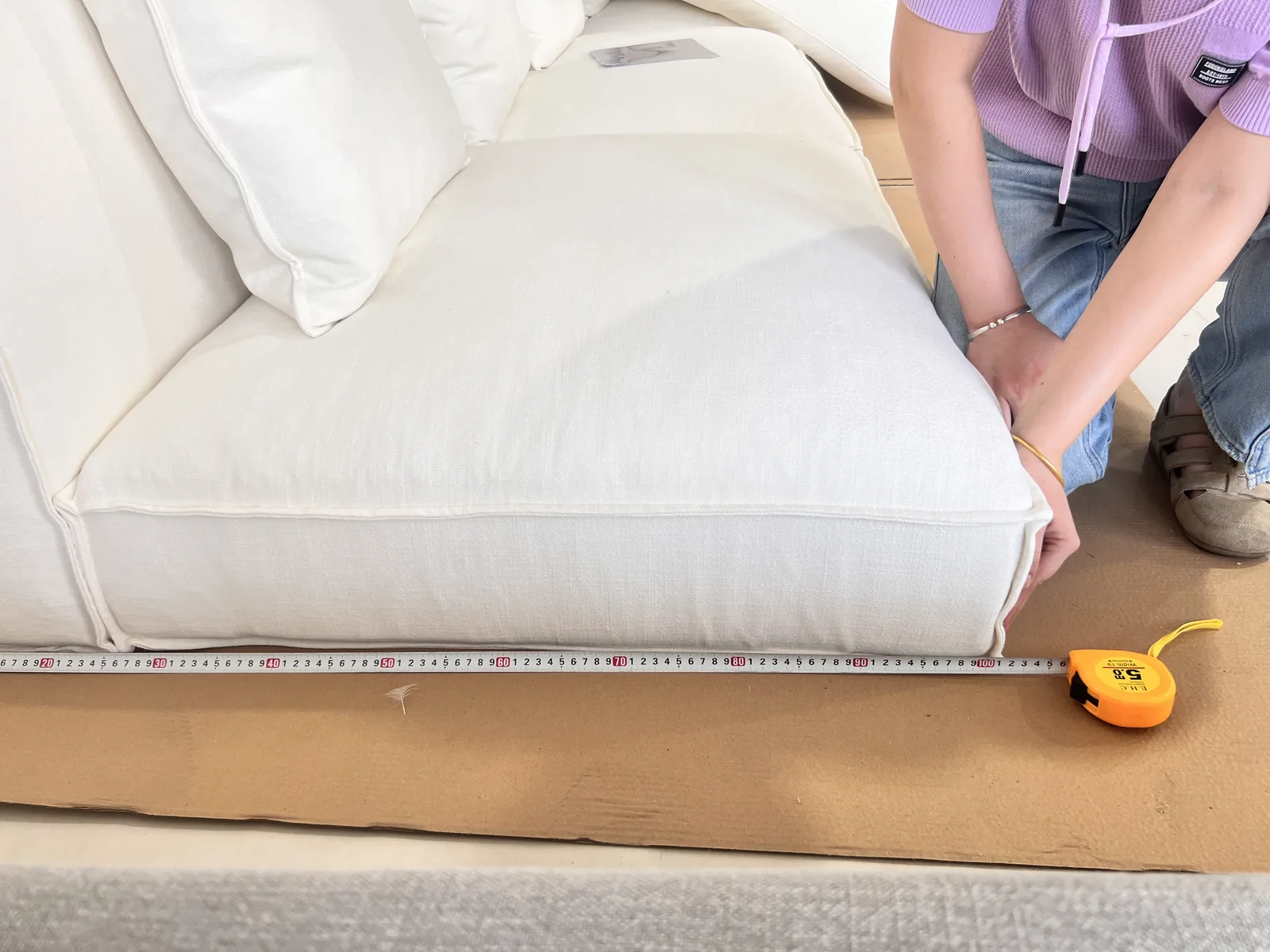Measuring a finished sofa in the Foshan consolidation warehouse against its spec sheet