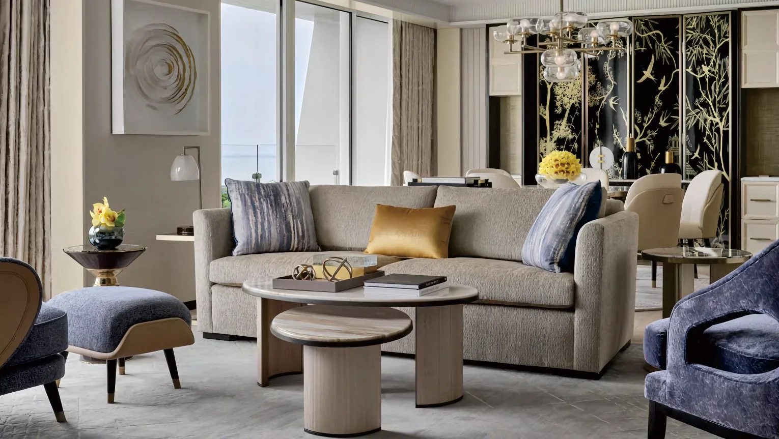 Hotel king guestroom with upholstered headboard, bench and desk in warm veneer