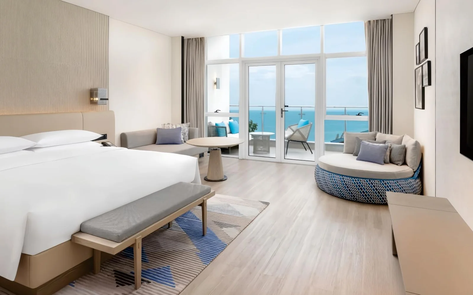 Sea-view hotel guestroom with bed, daybed and lounge chair