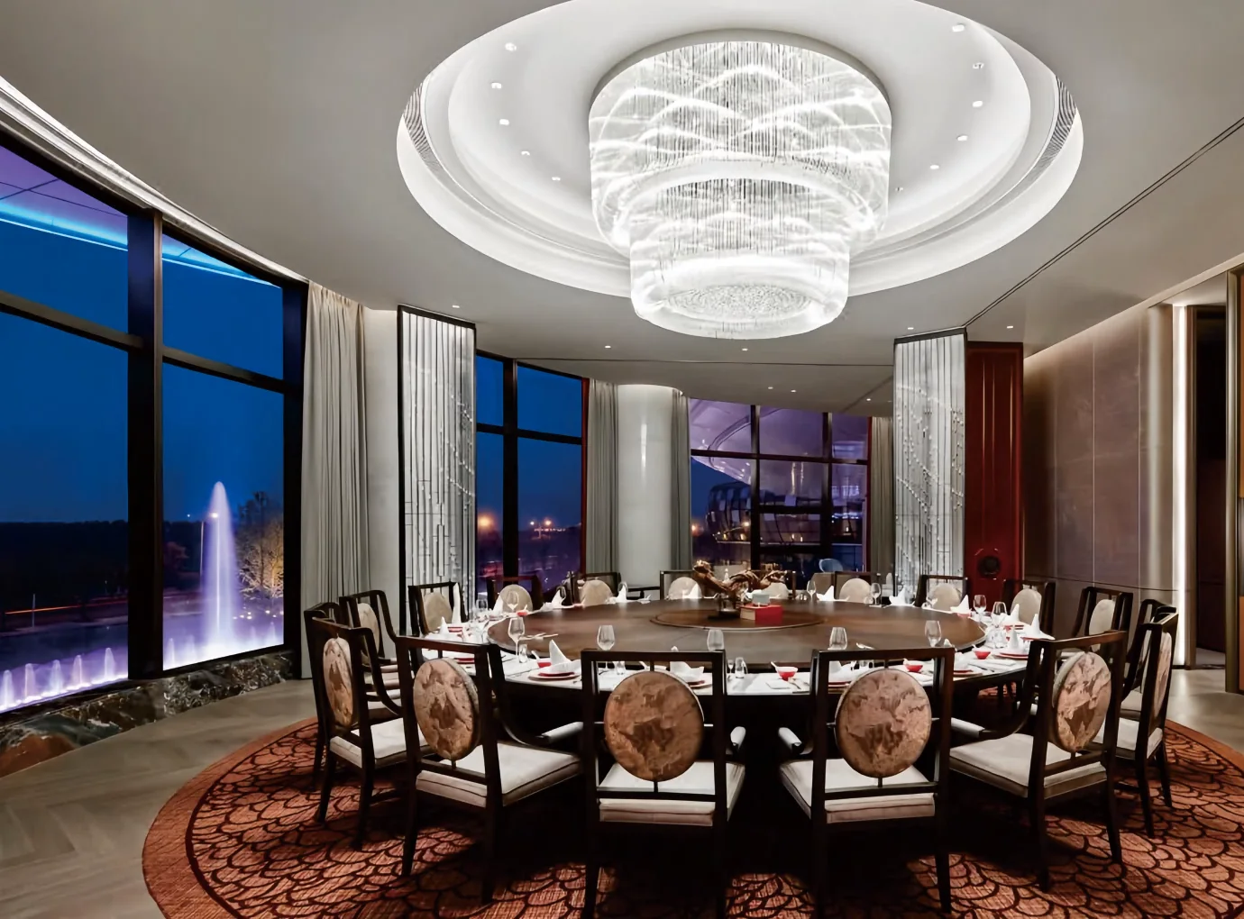Hotel private dining room with round table for twelve under a crystal chandelier