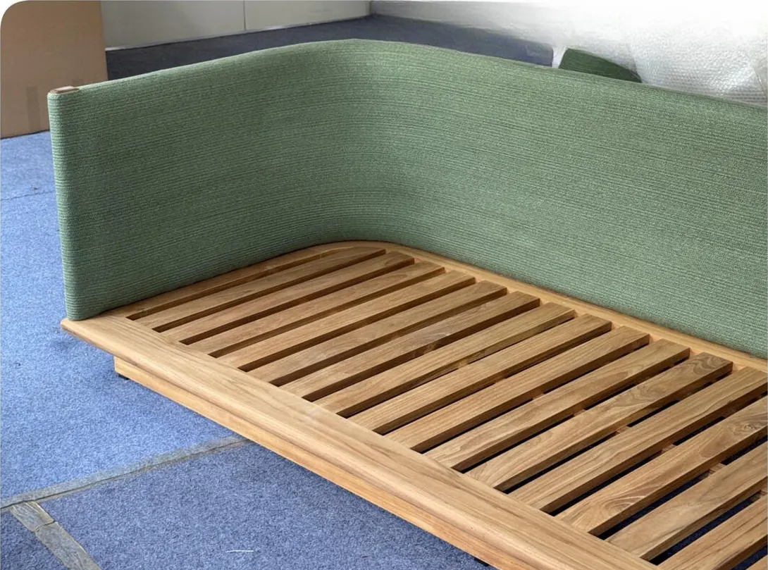 Finished outdoor sofa frame with green upholstered back on the factory floor