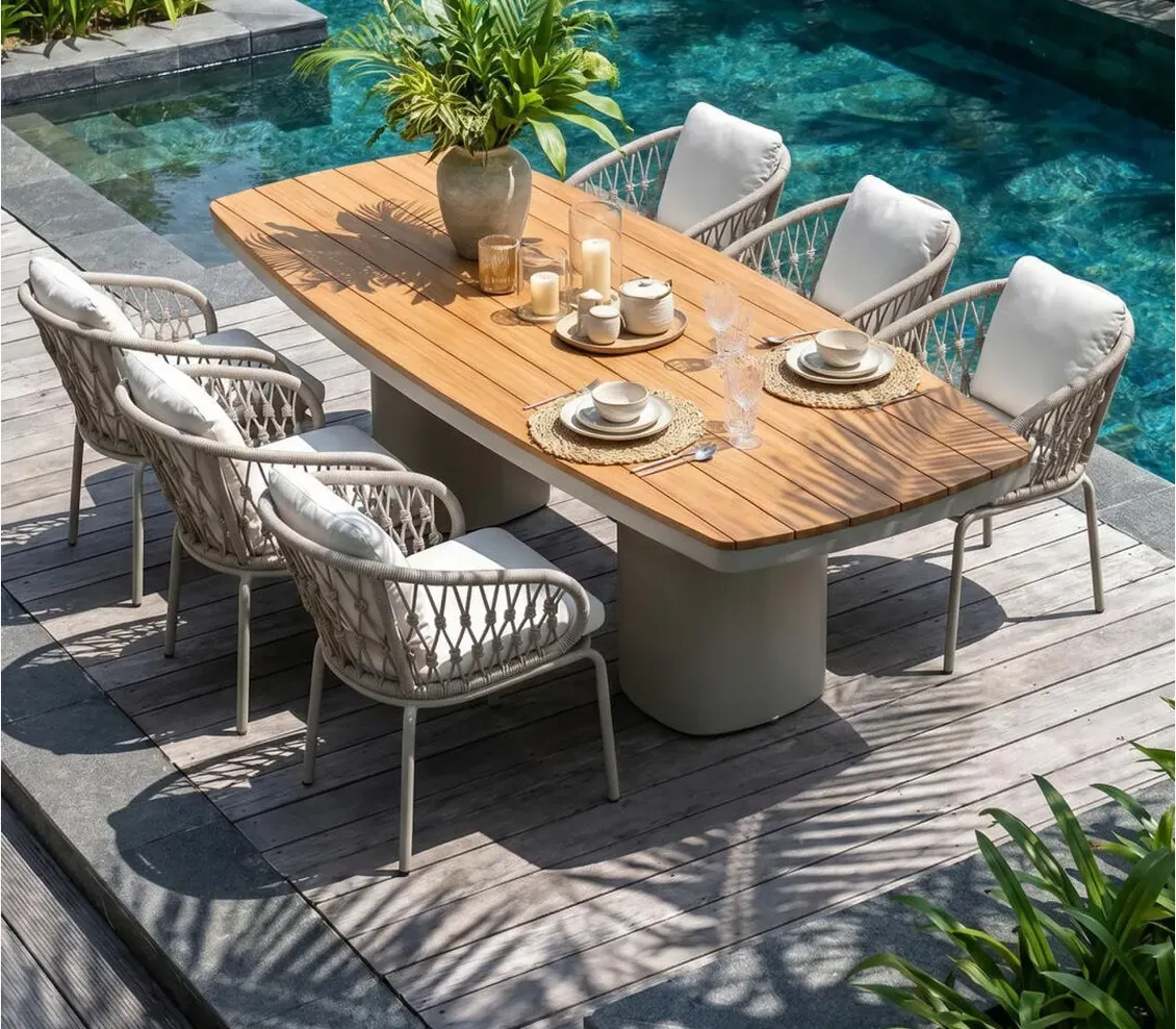 Teak outdoor dining table with rope-weave chairs on a pool deck, from a Foshan outdoor furniture factory