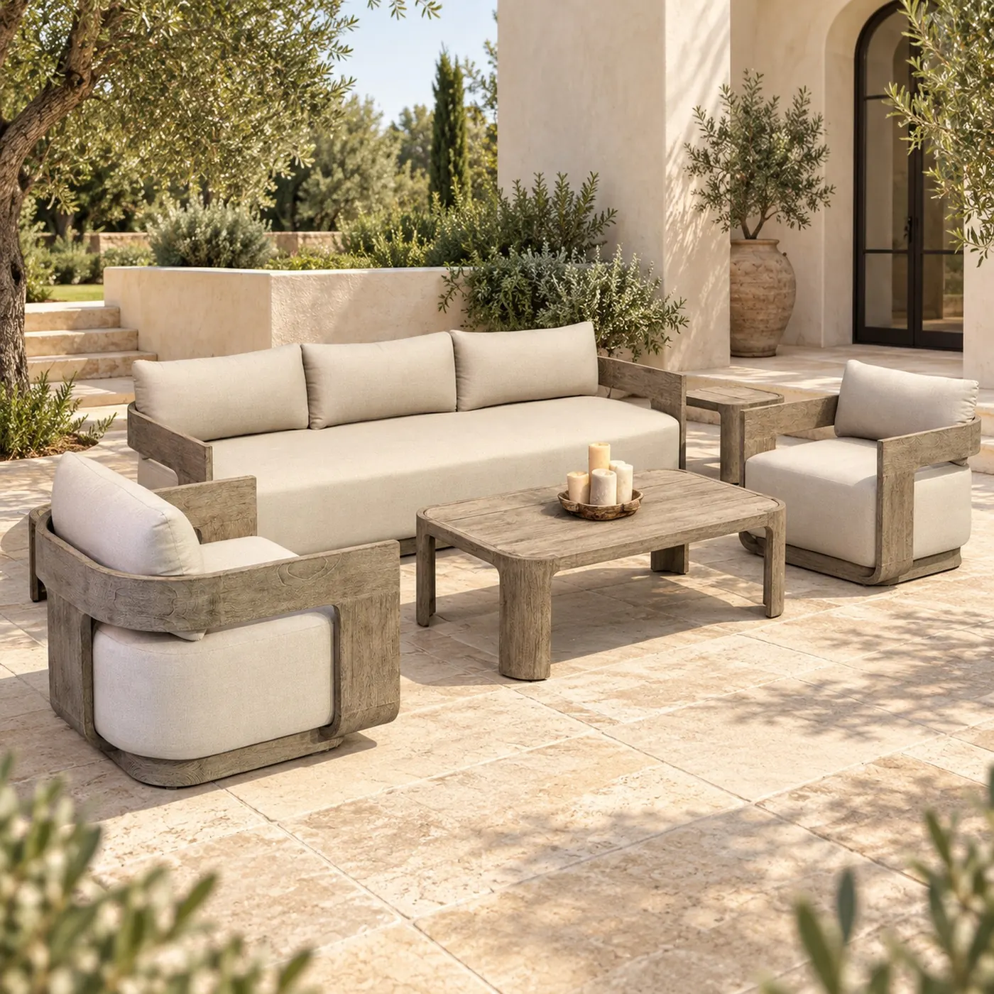 Teak-framed outdoor sofa set with cream cushions and a low table on a terrace