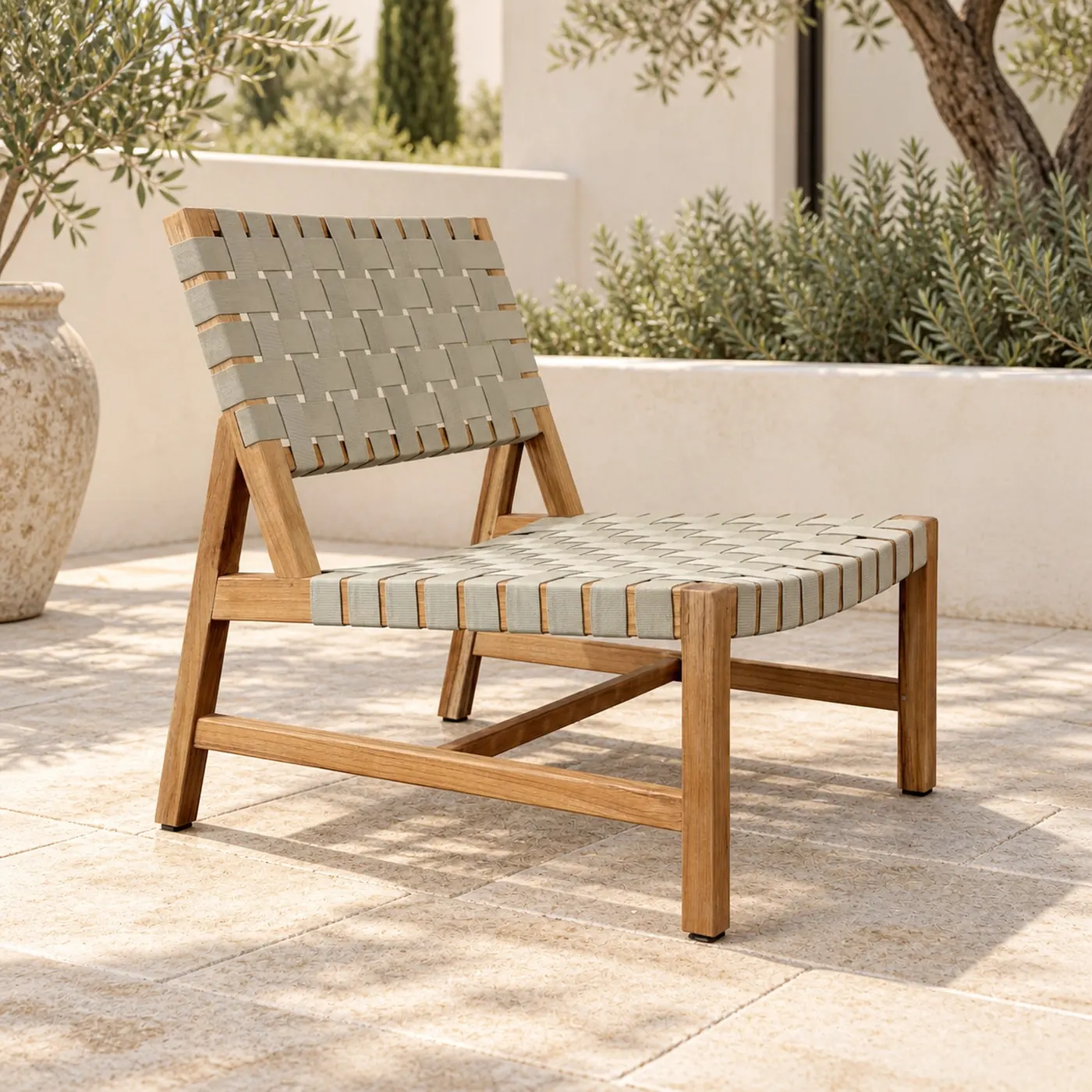 Teak lounge chair with woven webbing seat and back on a terrace