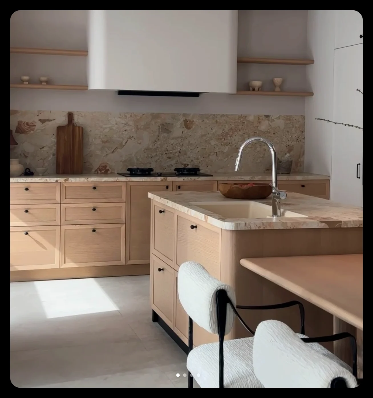 Light oak kitchen cabinetry with a stone splashback and island