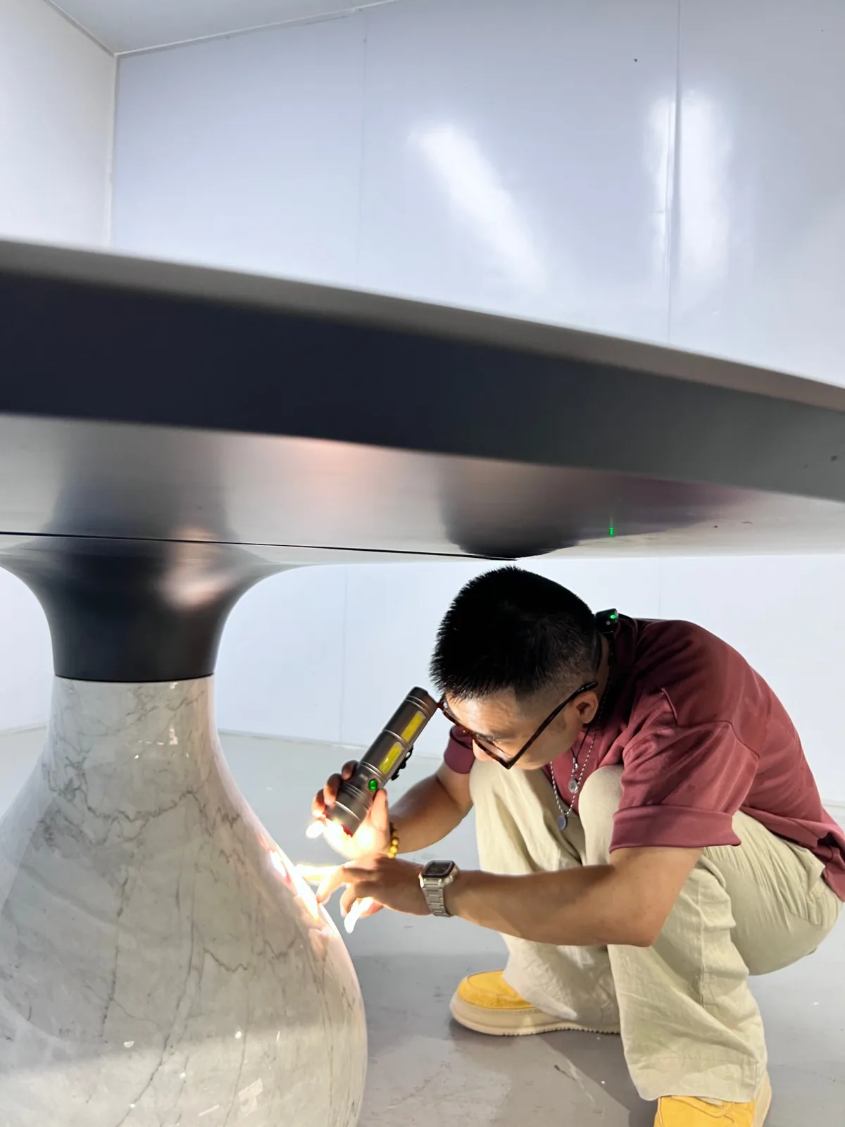 Inspector checking a marble table base with a torch