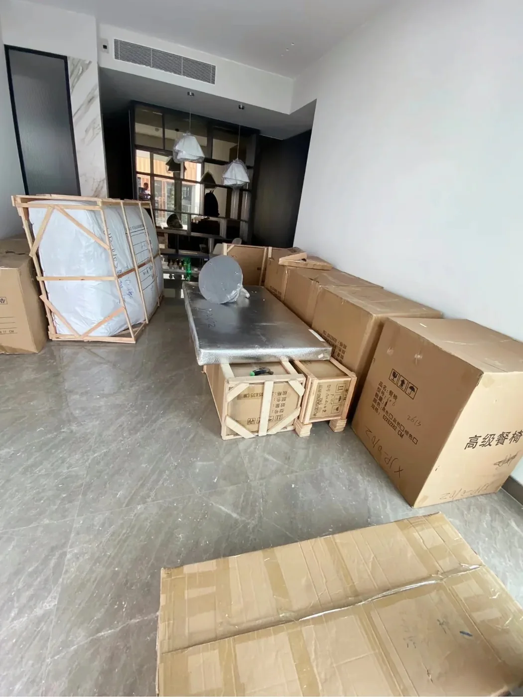 A crated sofa, foil-wrapped table top and cartons standing indoors in an Australian home