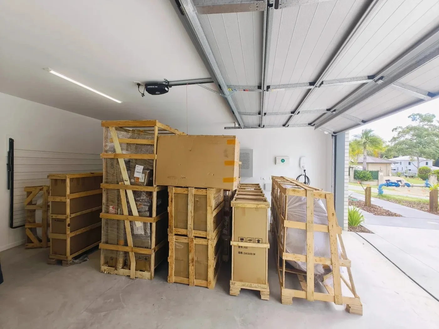 Timber-crated furniture lined up in a Brisbane garage after an LCL delivery