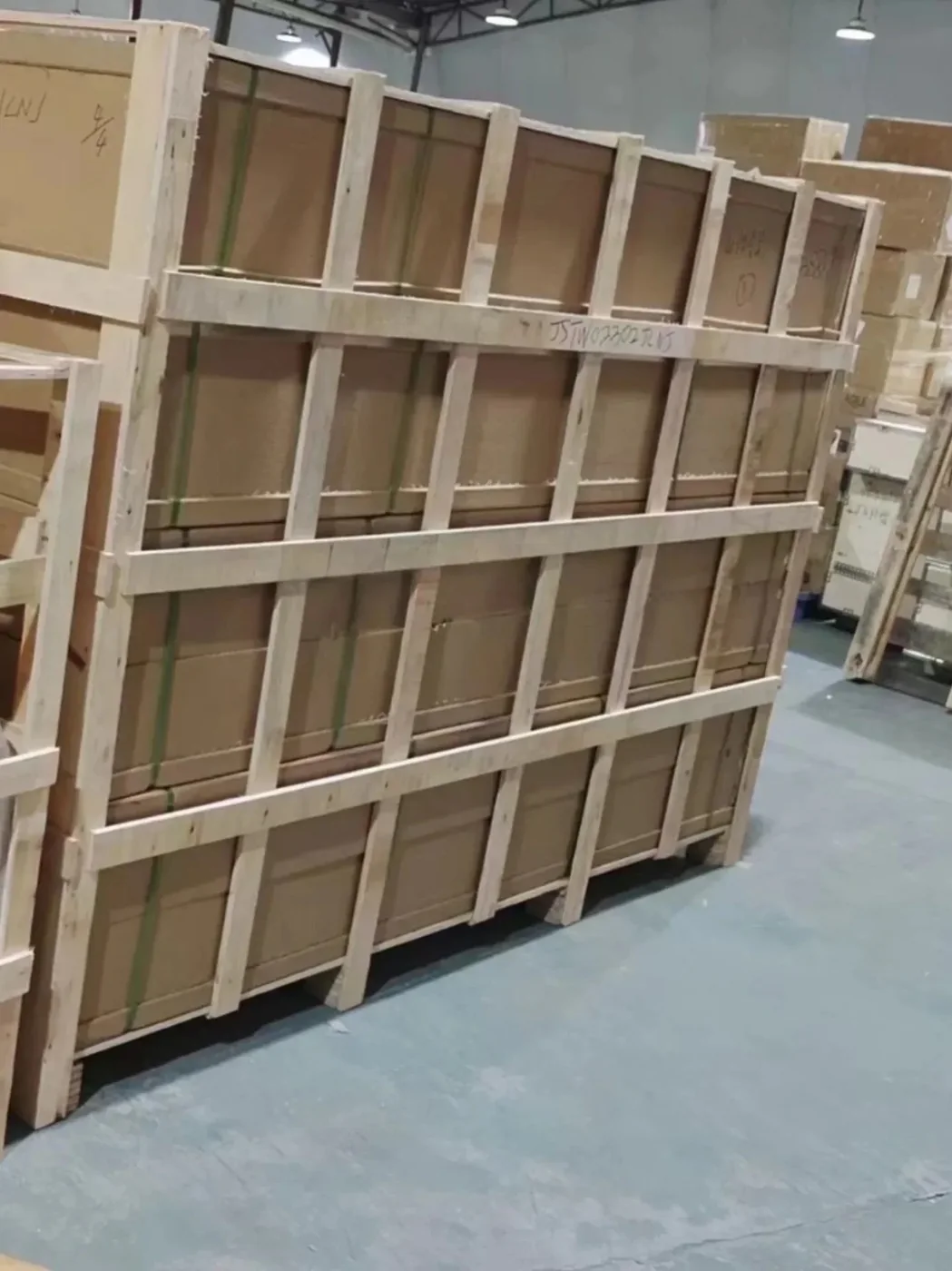 A row of large furniture cartons framed together in one long timber frame with an order number stencilled on