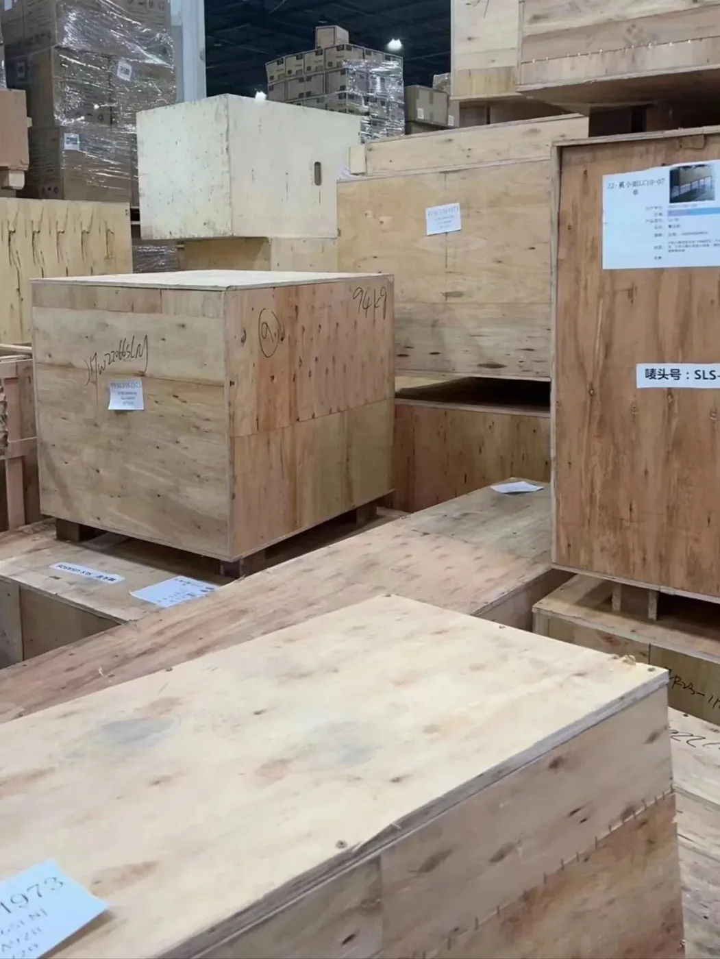 Plywood crates with shipping-mark numbers and cargo labels in a Chinese export warehouse