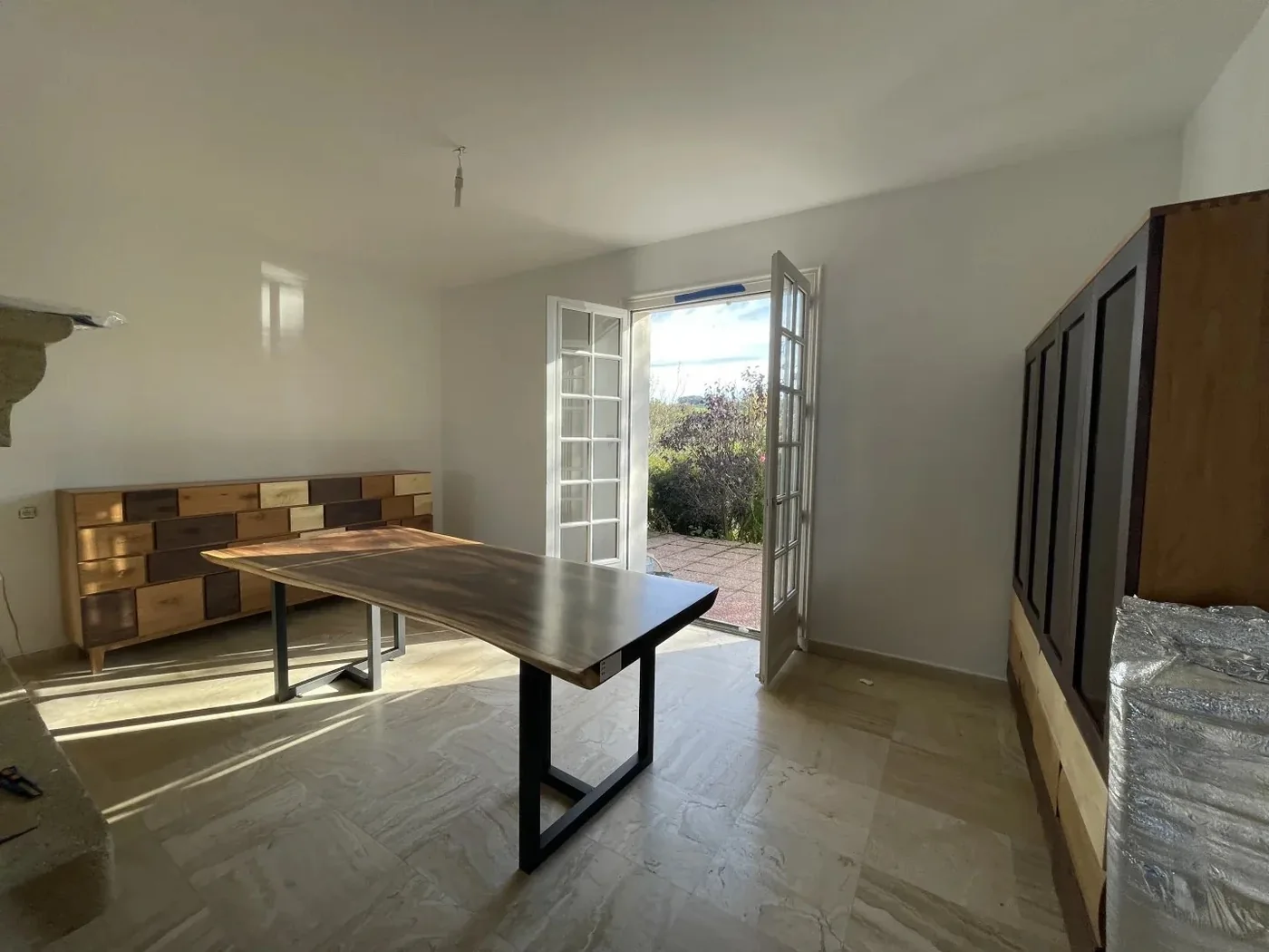 A live-edge solid-wood dining table and patchwork sideboard installed in a French house