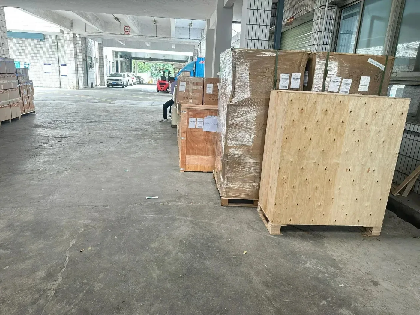 Plywood crates and stretch-wrapped pallets with shipping labels waiting to load for South Africa