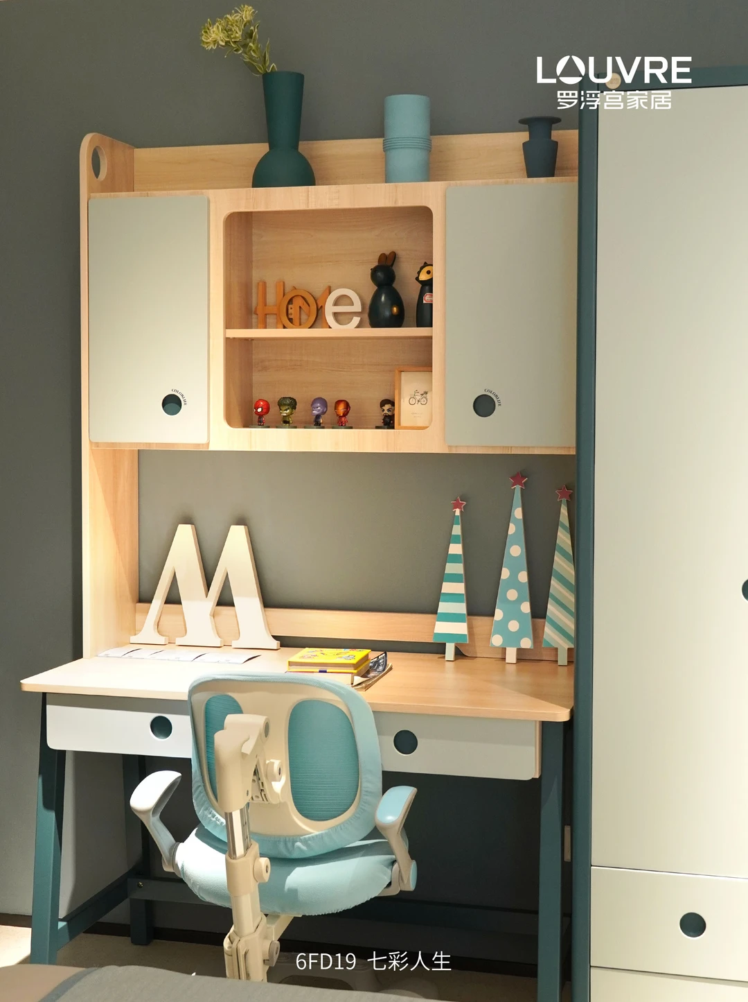 Green-and-white children’s study desk with a teal chair and integrated shelving.