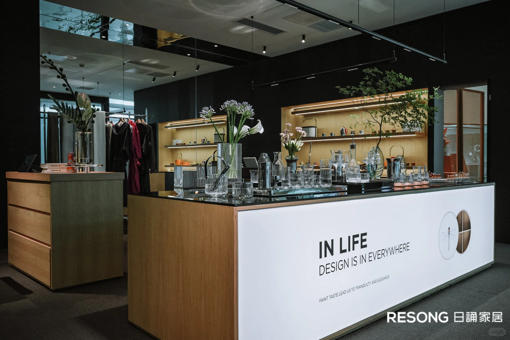 Timber display counter with glassware, bottles and illuminated shelves in the RESONG showroom.