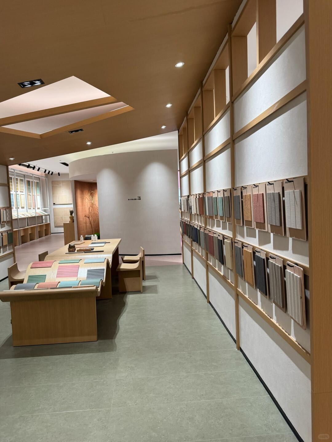 Tile comparison table beside two rows of hanging texture and colour sample boards.