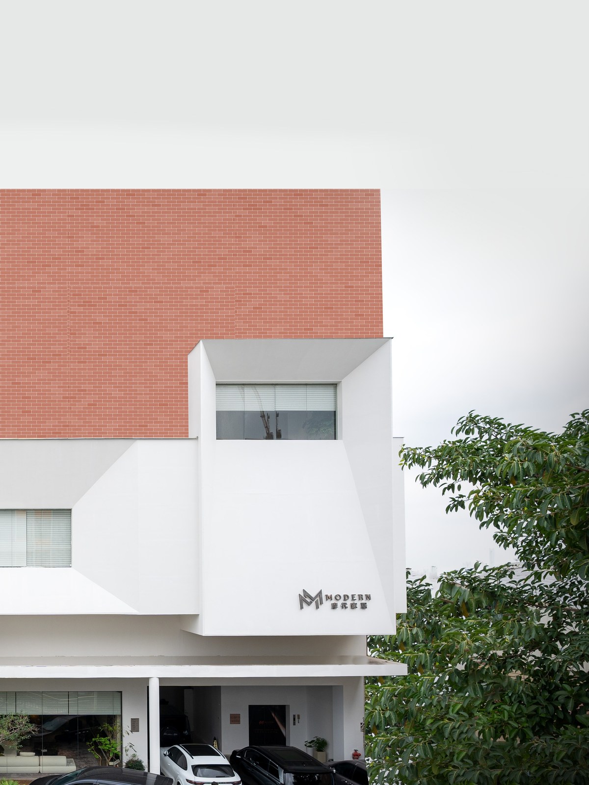 White and red-brick building exterior carrying the MODERN home-furnishing sign.