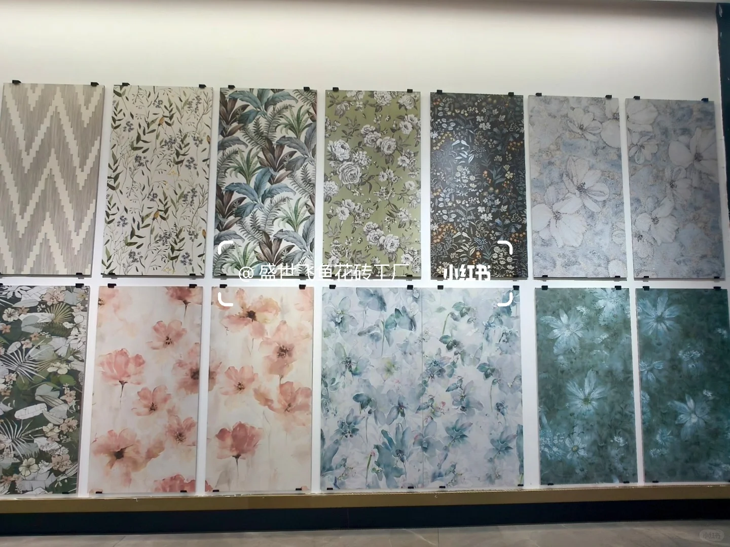 Two rows of large botanical and floral tile panels in soft pink, green and blue tones.