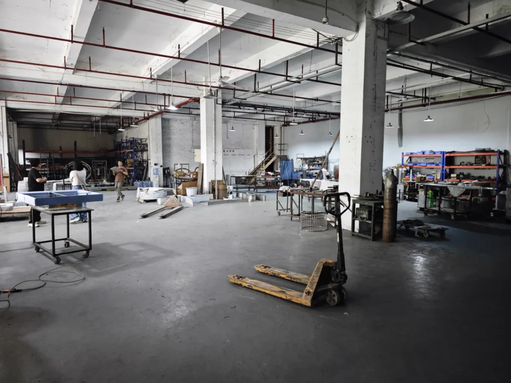 Large empty factory hall with a pallet jack on a bare concrete floor