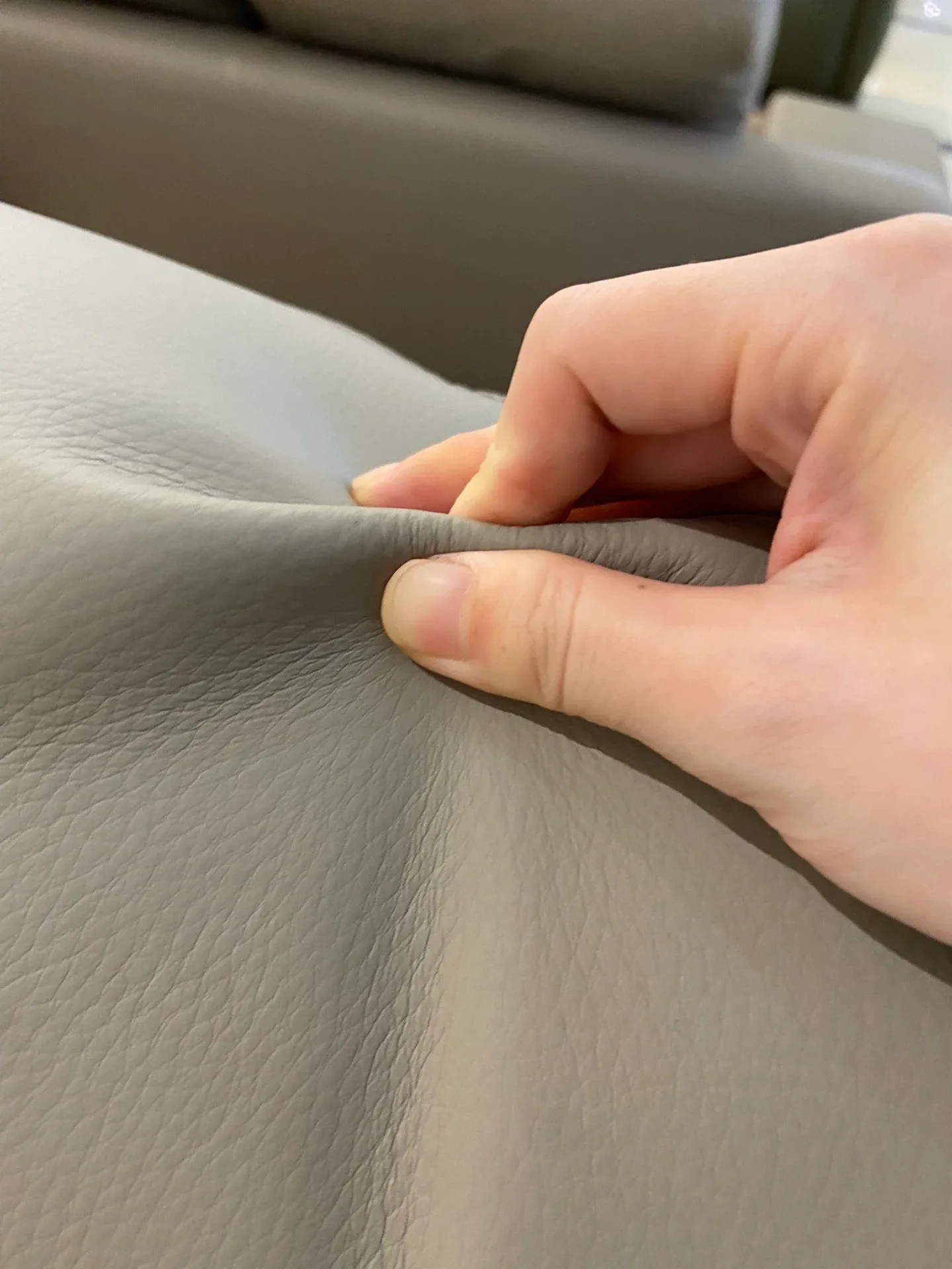 The same maker's post pinches the cover to show a supple, grained leather — ask in writing which surfaces are top-grain and which are not.