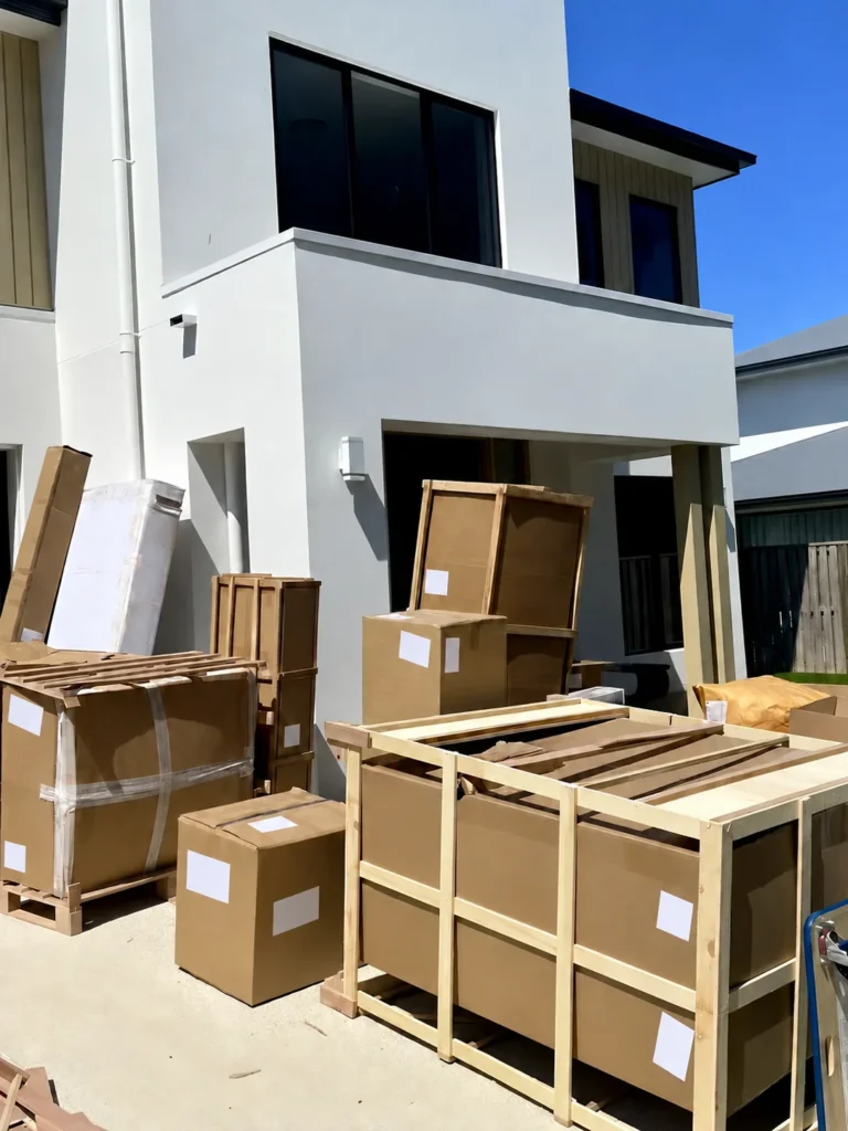 Furniture packed in wooden export crates outside a home before final delivery