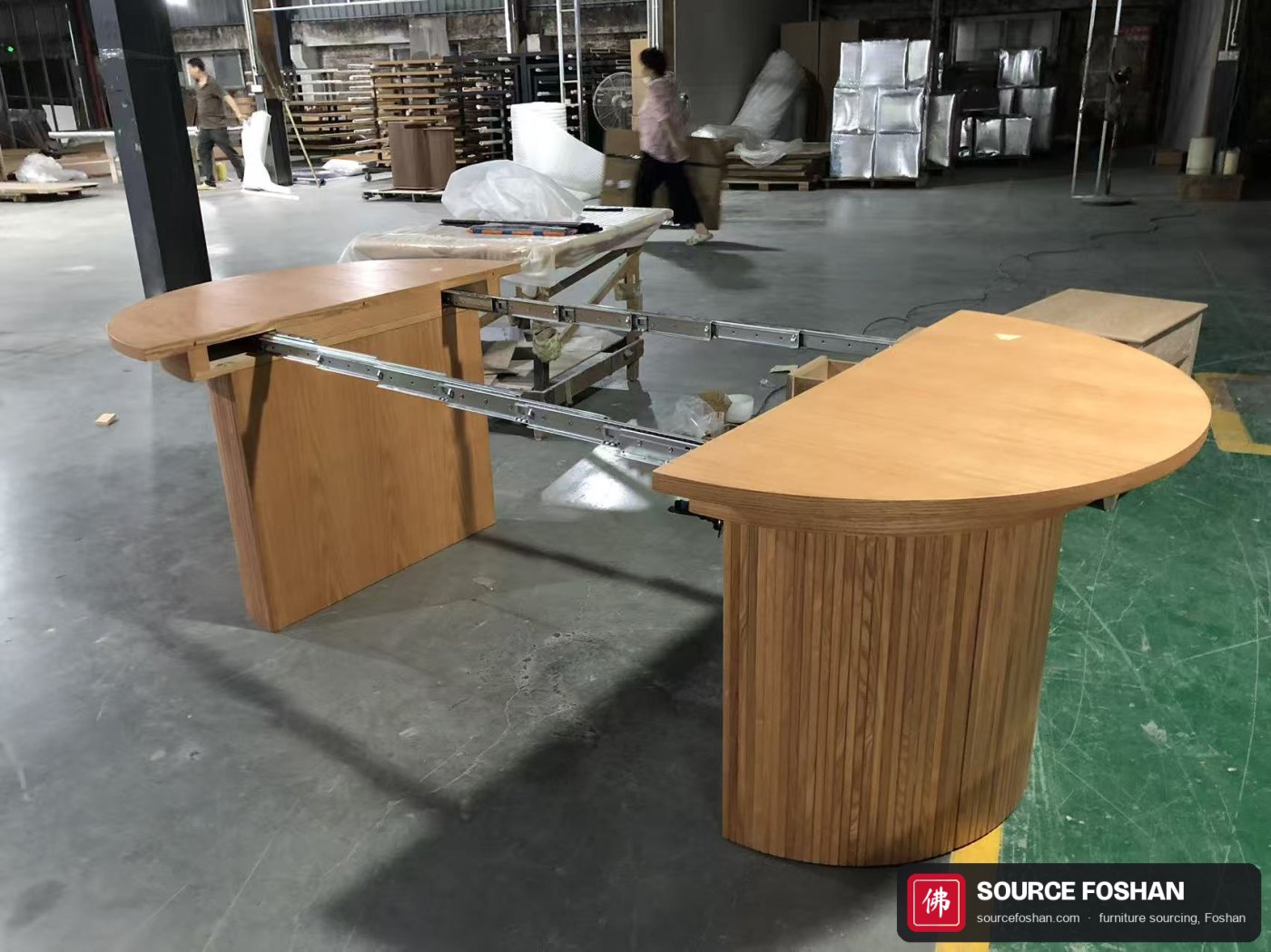 Full extension: both table halves apart with the steel slide rails and second pedestal visible