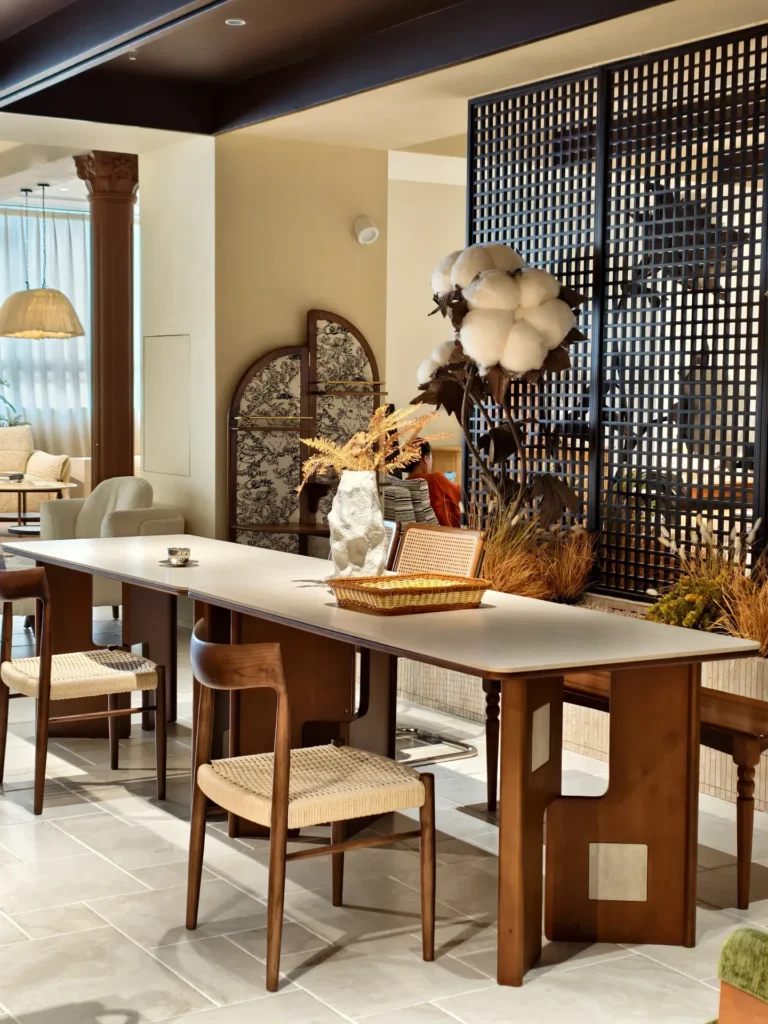 A dining set with a stone-look top in a 6,000 m² showroom in an industrial park in Jiujiang, Nanhai — one of the manufacturer showrooms spread across.