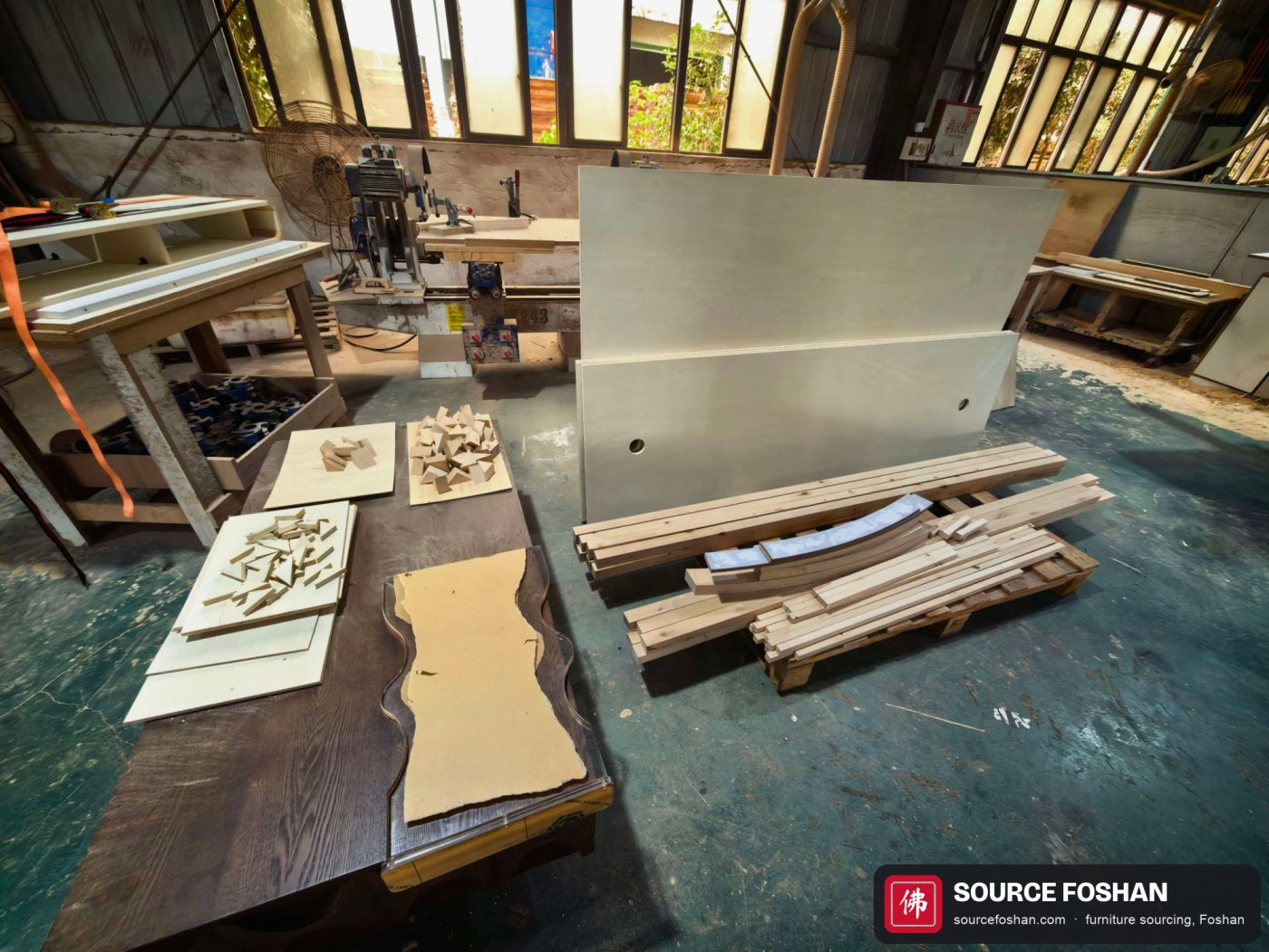 Workshop bench with templates, jigs and machined oak strips used to build the curved fluted base