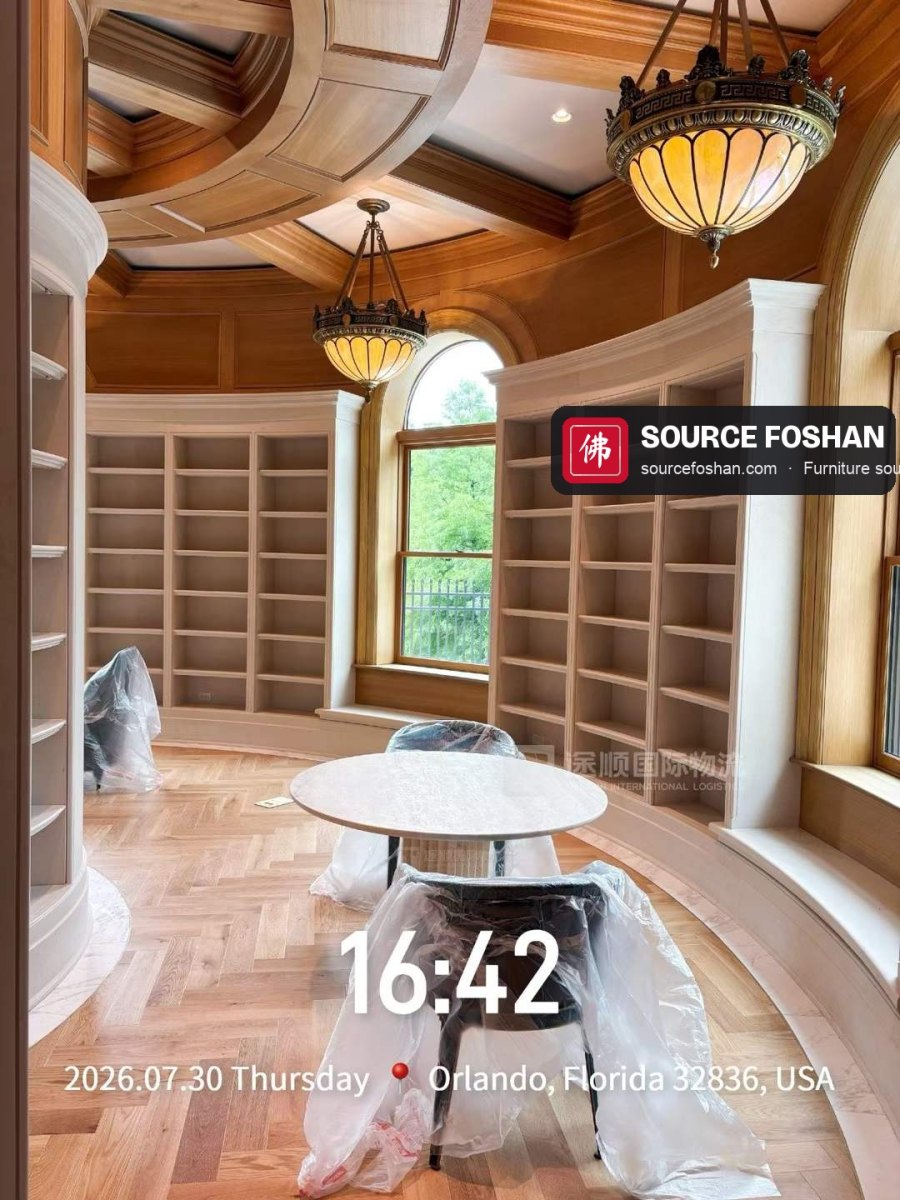 Round marble table and chairs set out in a curved library, Orlando