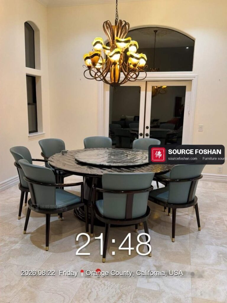 Round marble dining table and eight chairs from Foshan installed under a chandelier