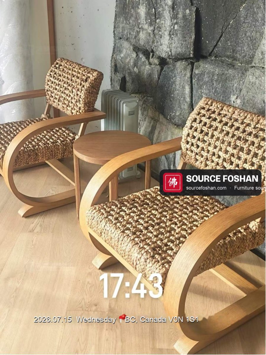 Woven lounge chairs and oak side table from Foshan unpacked beside a stone wall