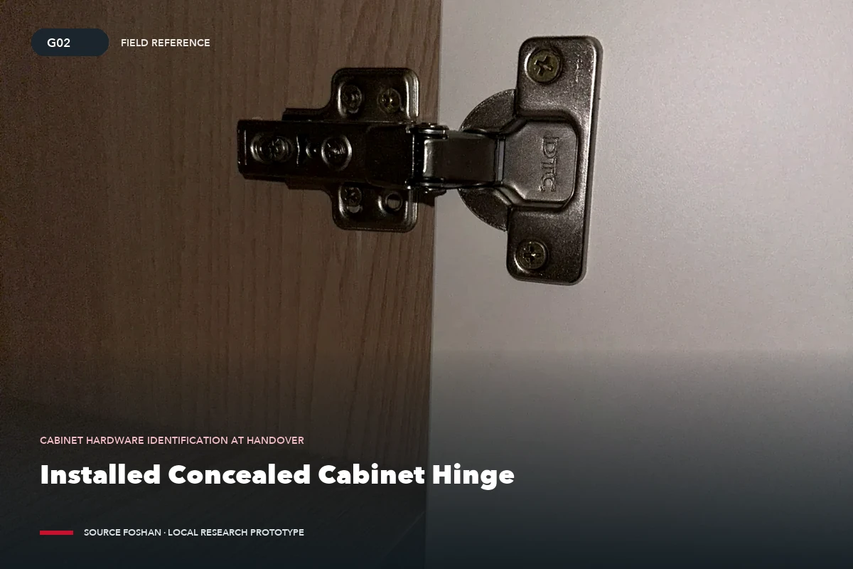 Close-up of a concealed cabinet hinge installed between a cabinet door and carcass.