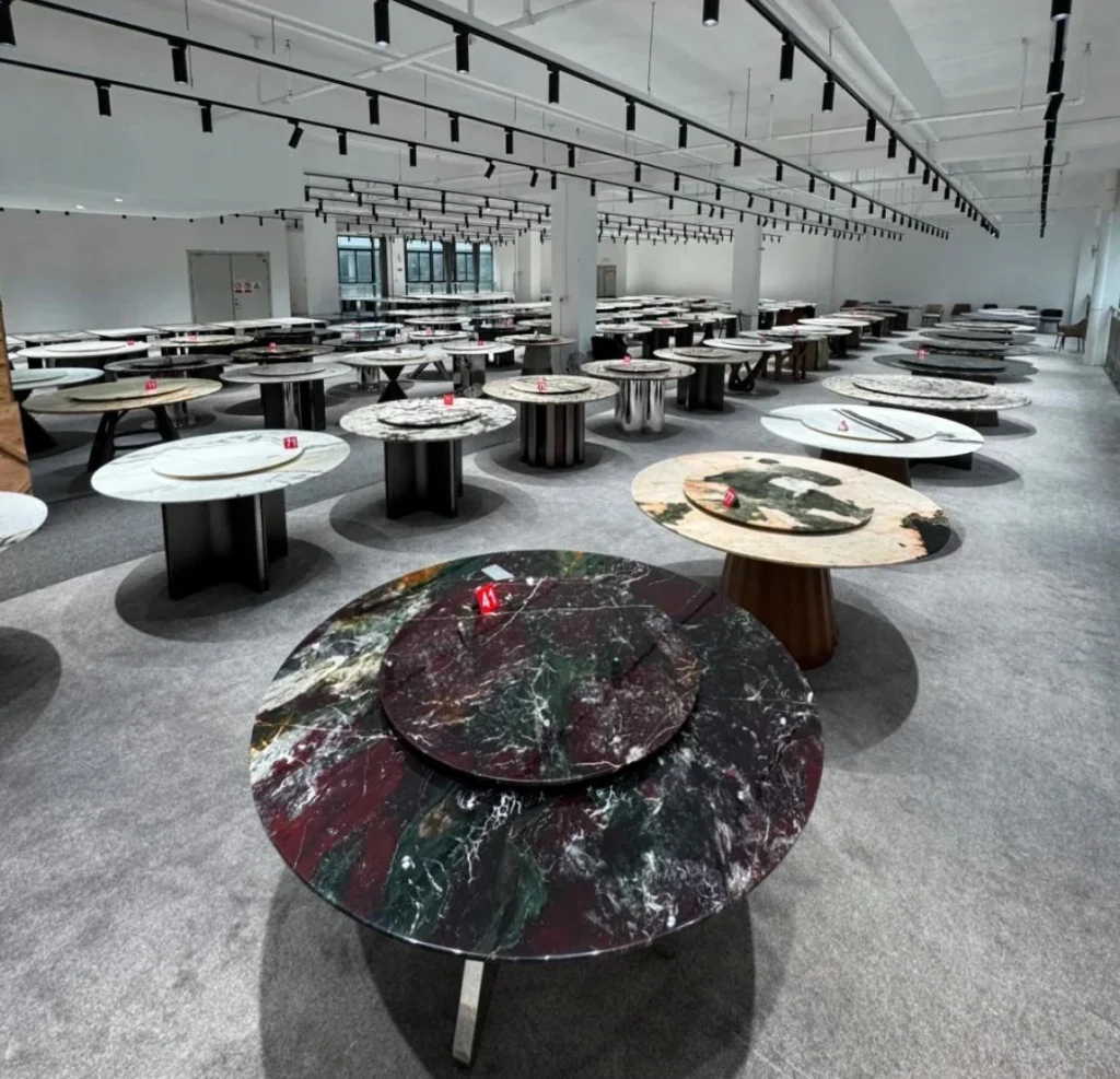 Stone dining tables with different marble and sintered-stone tops displayed in a showroom