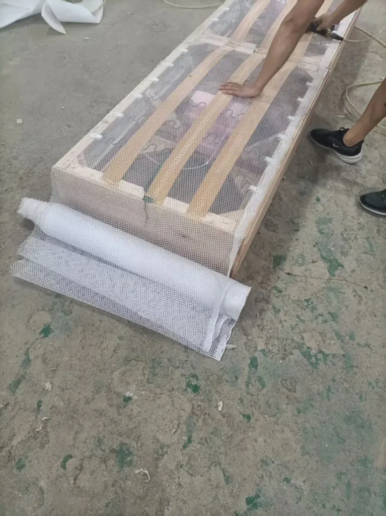 Slatted bed bases stacked and packed in batches at a bed factory in Lecong, Foshan