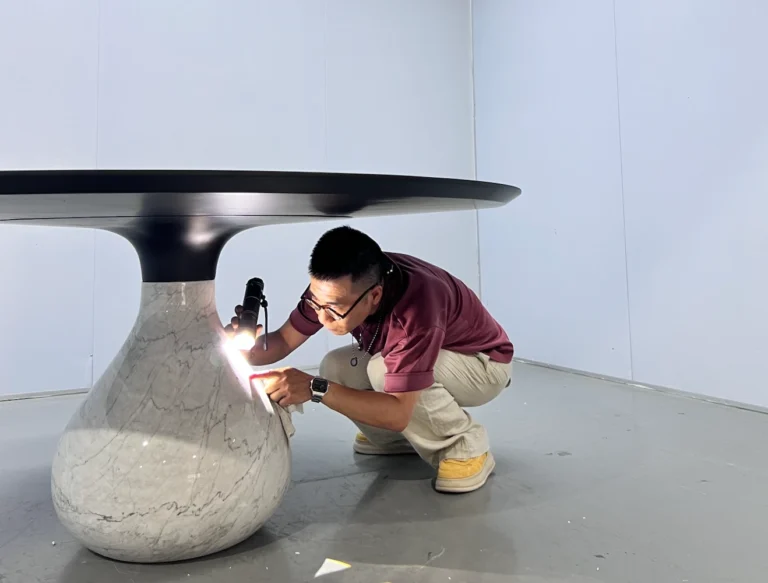 Source Foshan inspector checking a dining table with a flashlight before shipment