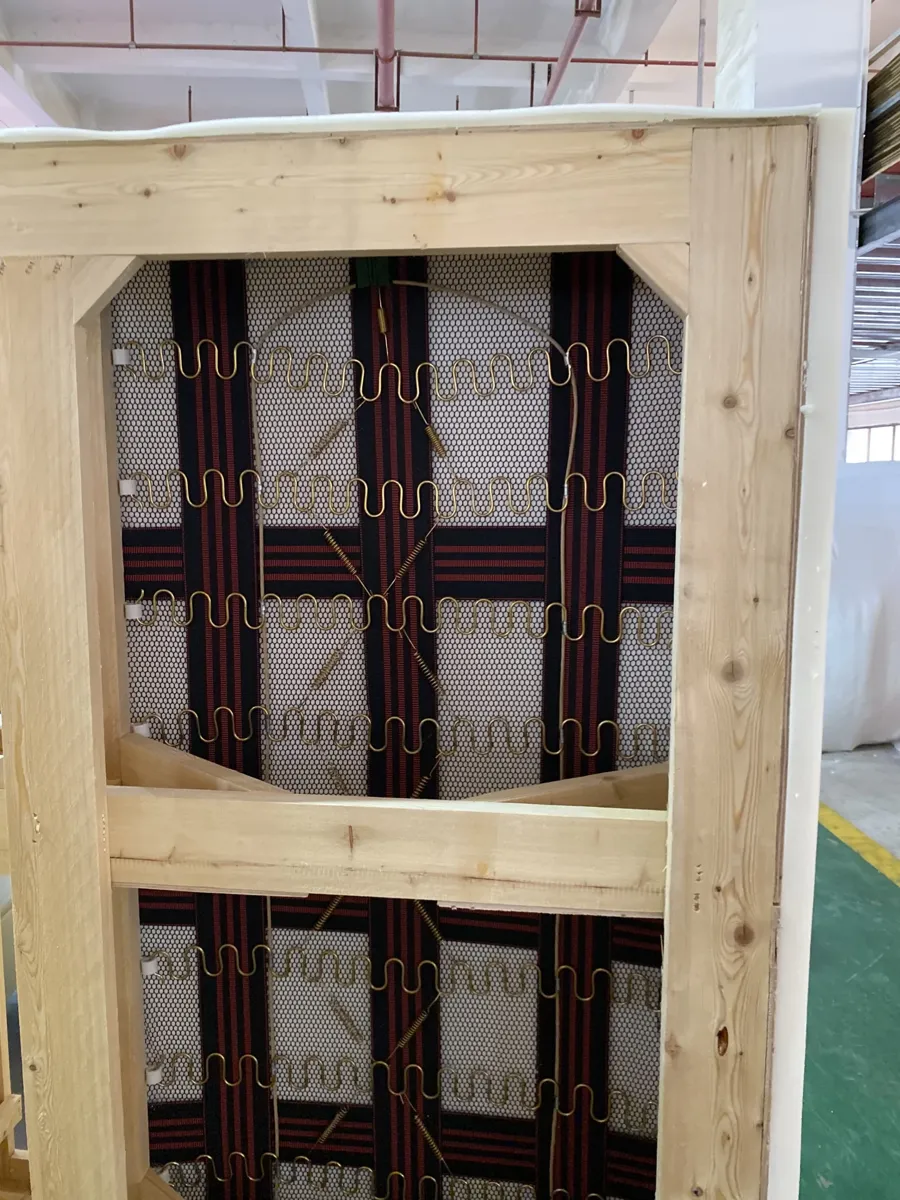 A bare sofa frame with webbing, before foam and cover — the stage to film.