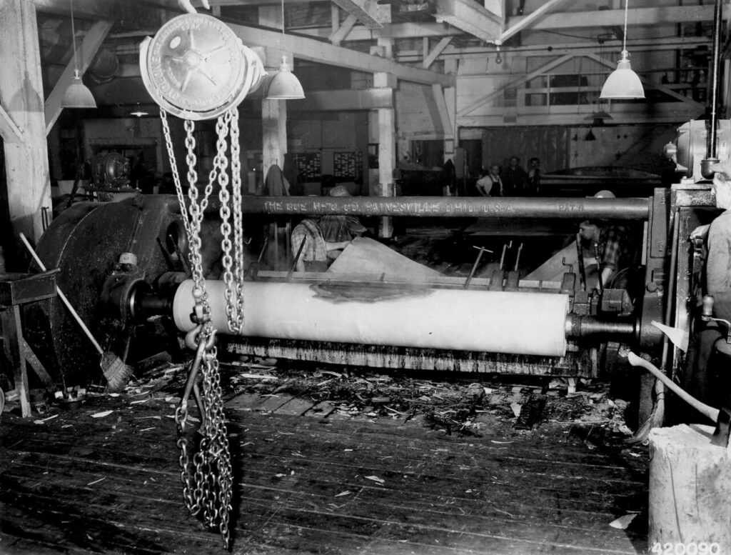 Unrelated historical veneer-cutting photograph illustrating an upstream process