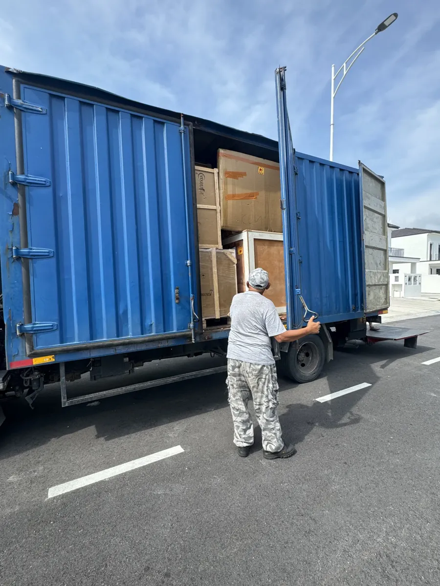 The same delivery: cartons and wooden-framed crates packed together in the lorry.