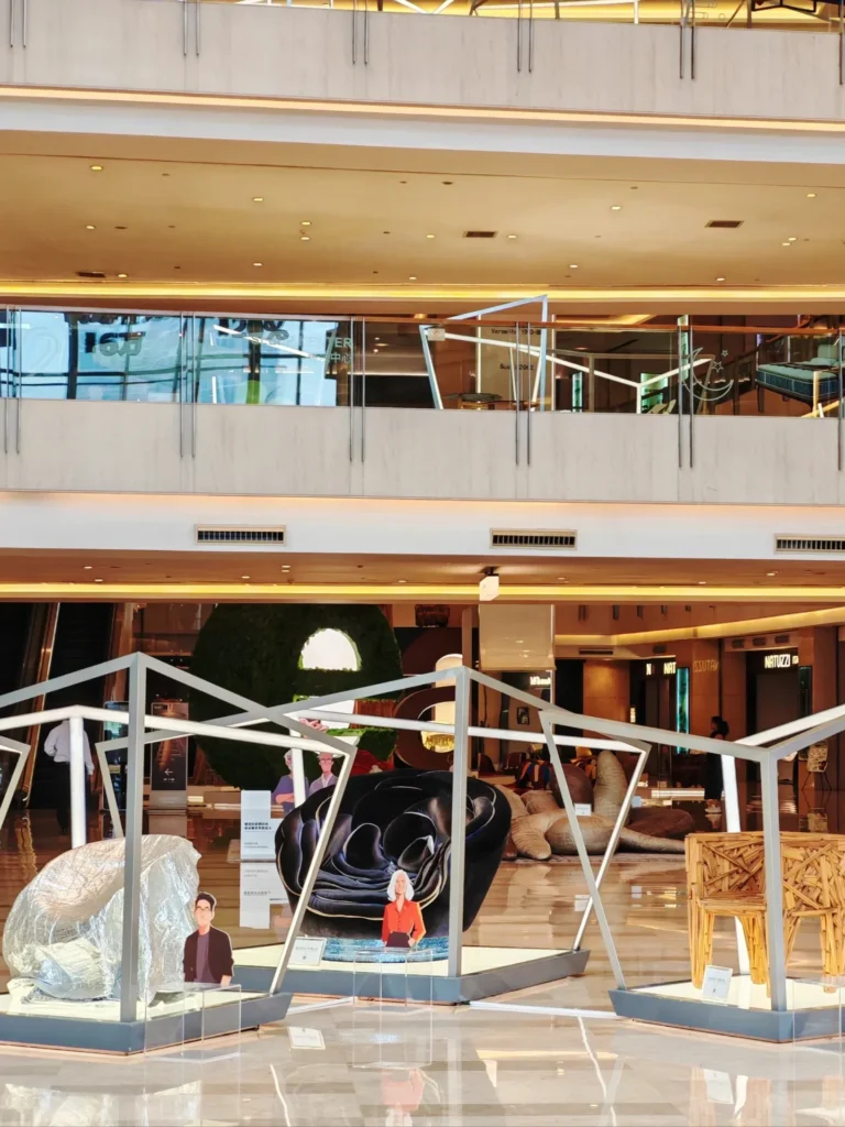 Inside the Louvre Furniture Mall: a designer-chair exhibition in the atrium, with international brand stores behind. Showpiece malls like this are.