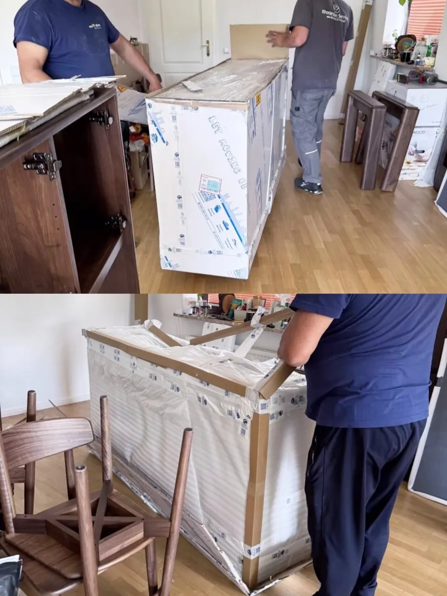 A delivery crew unpacking a wrapped sideboard in a German buyer's home; the service included carrying upstairs and removing packaging.