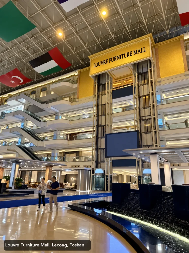The atrium of Louvre Furniture Mall in Lecong, Foshan, photographed by a visiting buyer. Bilingual signs point to themed floors such as Louvre Casa.