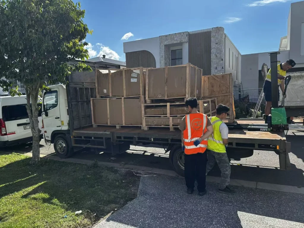 Furniture delivery crew and timber-framed goods outside the Melbourne home
