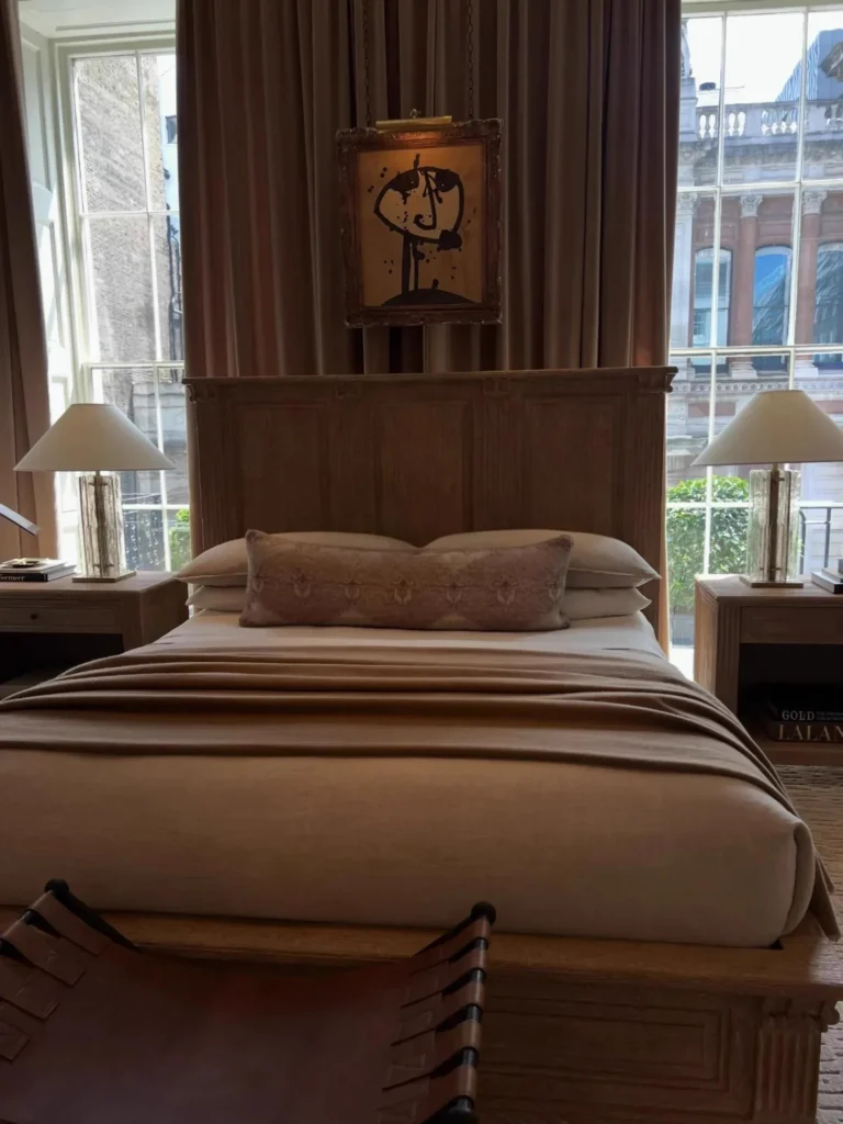 A bedroom in the high-end showroom photographed by an OEM seller: panelled timber headboard, linen bedding, oak side tables. Whether a factory copies.