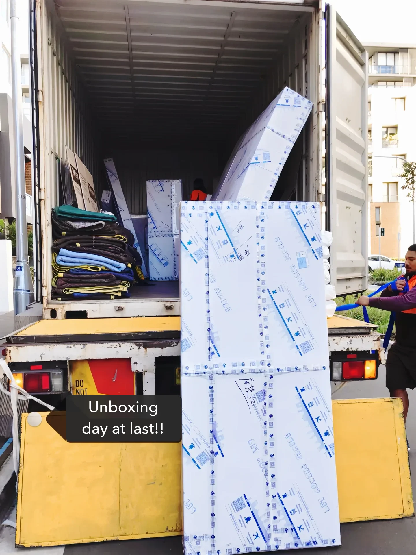 Unloading day in Canada: foam- and board-wrapped furniture coming off the delivery truck.