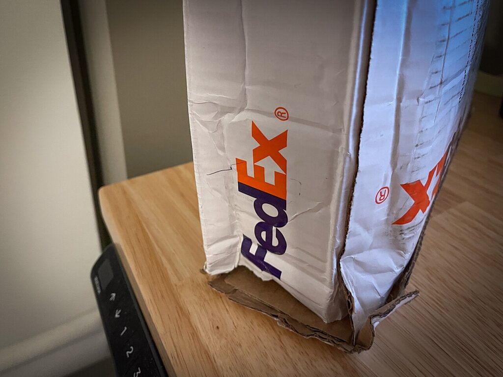 Unrelated damaged parcel illustrating a corner-protection failure mode